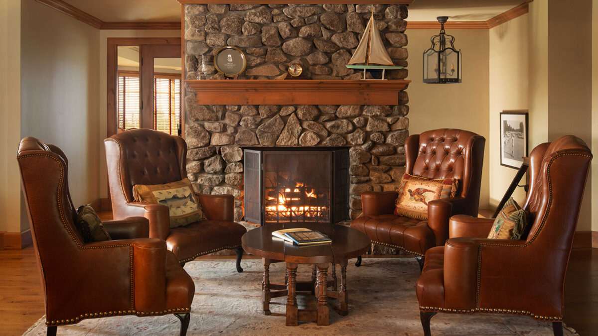 A cozy sitting area with a fireplace lit at Lake Winnipesaukee Golf Club.