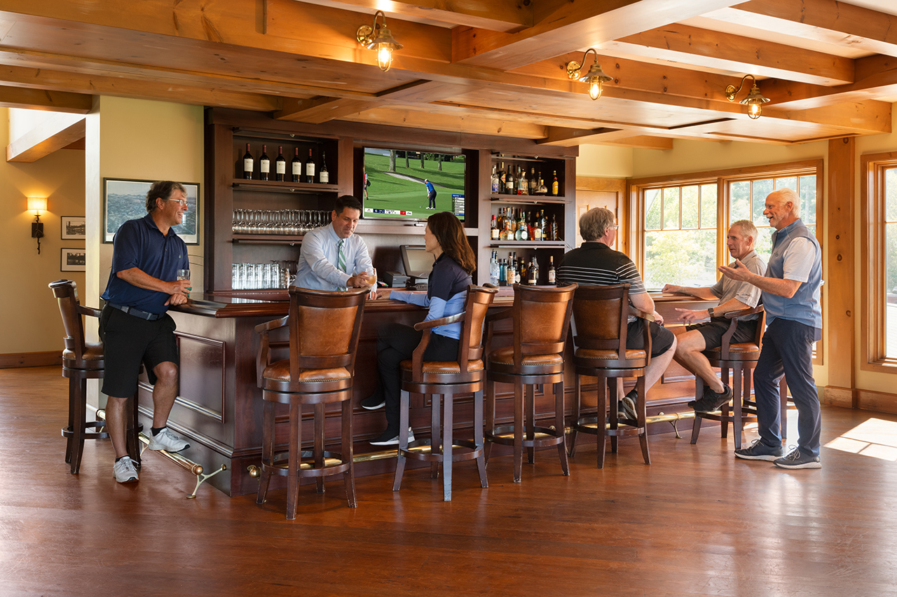 People socializing at the Lake Winnipesaukee Golf Club bar.